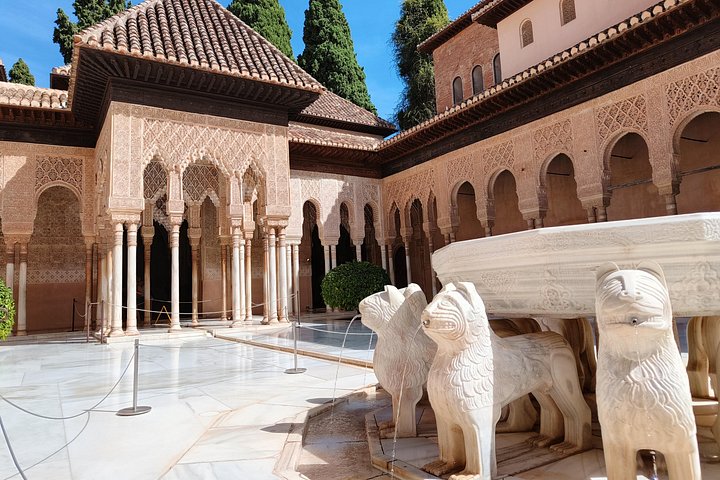 Stone lions supporting the courtyard fountain beside carved Nasrid arcades