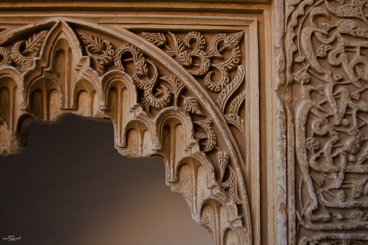 Carved floral plasterwork framing a small horseshoe arch
