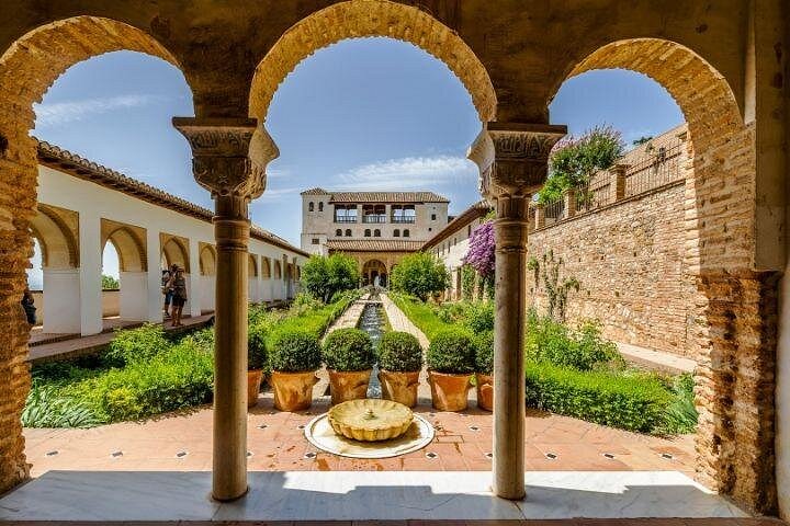 Arches framing the Generalife courtyard and its fountain-lined pool