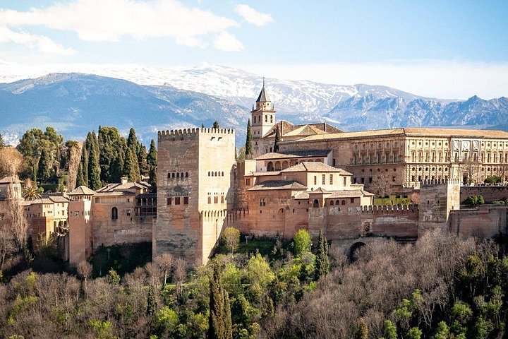 Alhambra walls and towers above Granada with mountains beyond