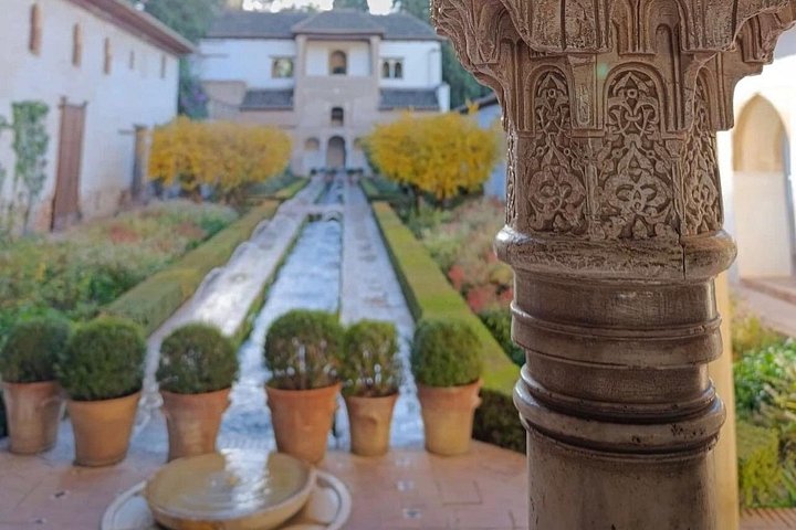 Generalife’s planted courtyard and water channel seen past a carved column
