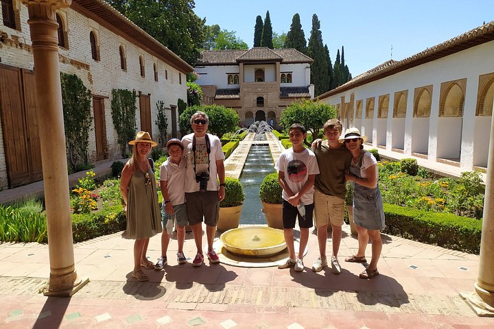 A family group beside the water channel and gardens of the Generalife