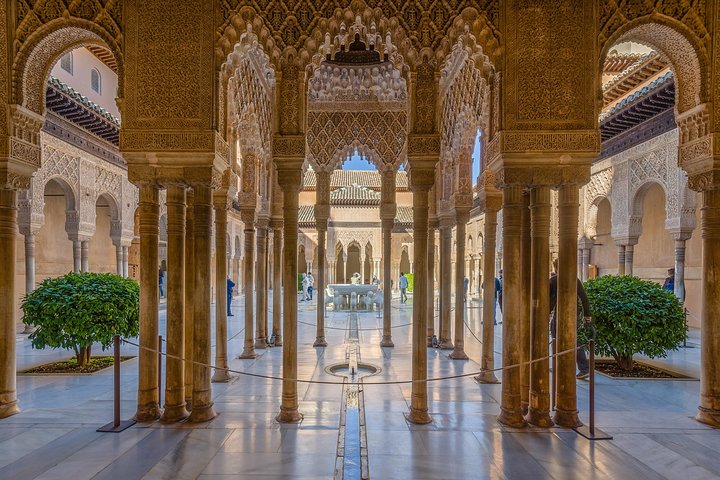 Slender columns and carved arches opening onto the Court of the Lions