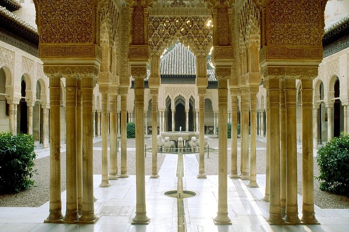 Carved arches and white marble columns beside the Court of the Lions