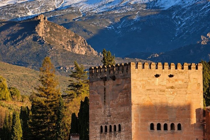 An Alhambra fortress tower beneath the snow-covered Sierra Nevada